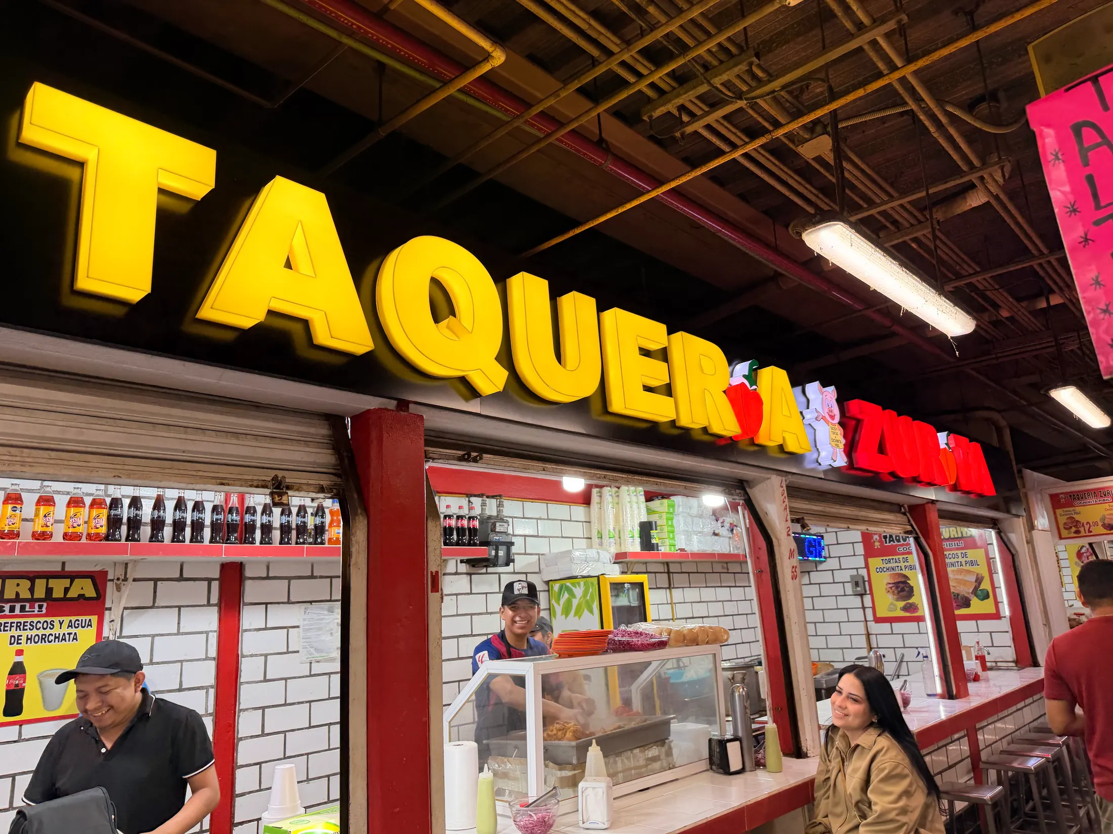 Letras 3D amarillas retroiluminadas de Taquería La Zona en el interior del local